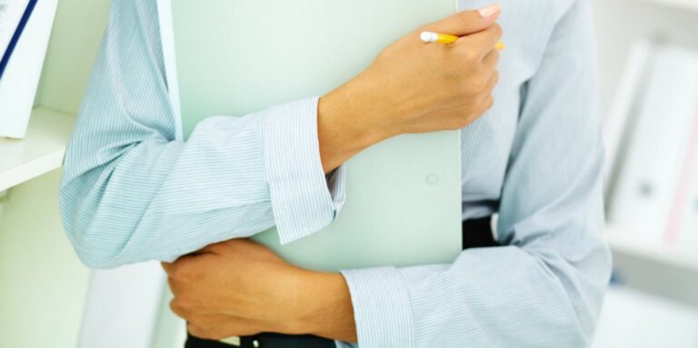 Image of a women holding a clip board close to her chest