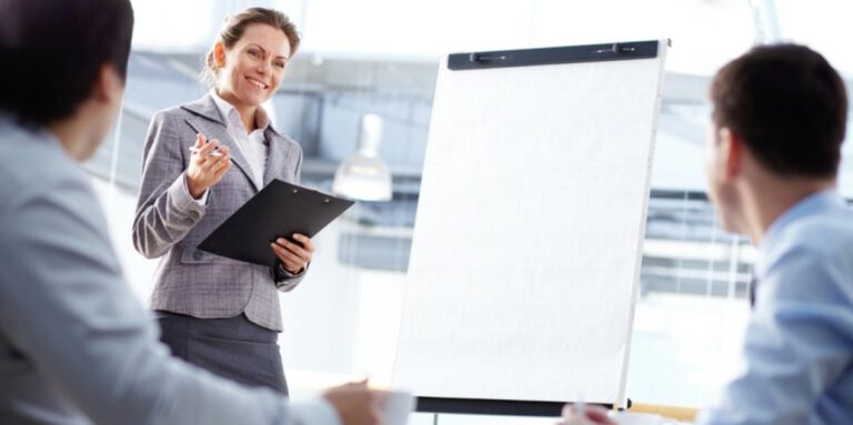 Image of a woman at a flip chart delivering leadership training