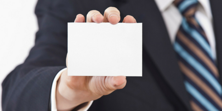 A hand holding up a blank business card