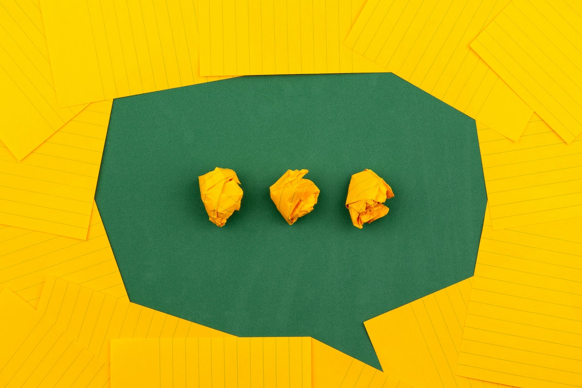 meaning at work yellow lined paper speach bubble with 3 crumpled up dots