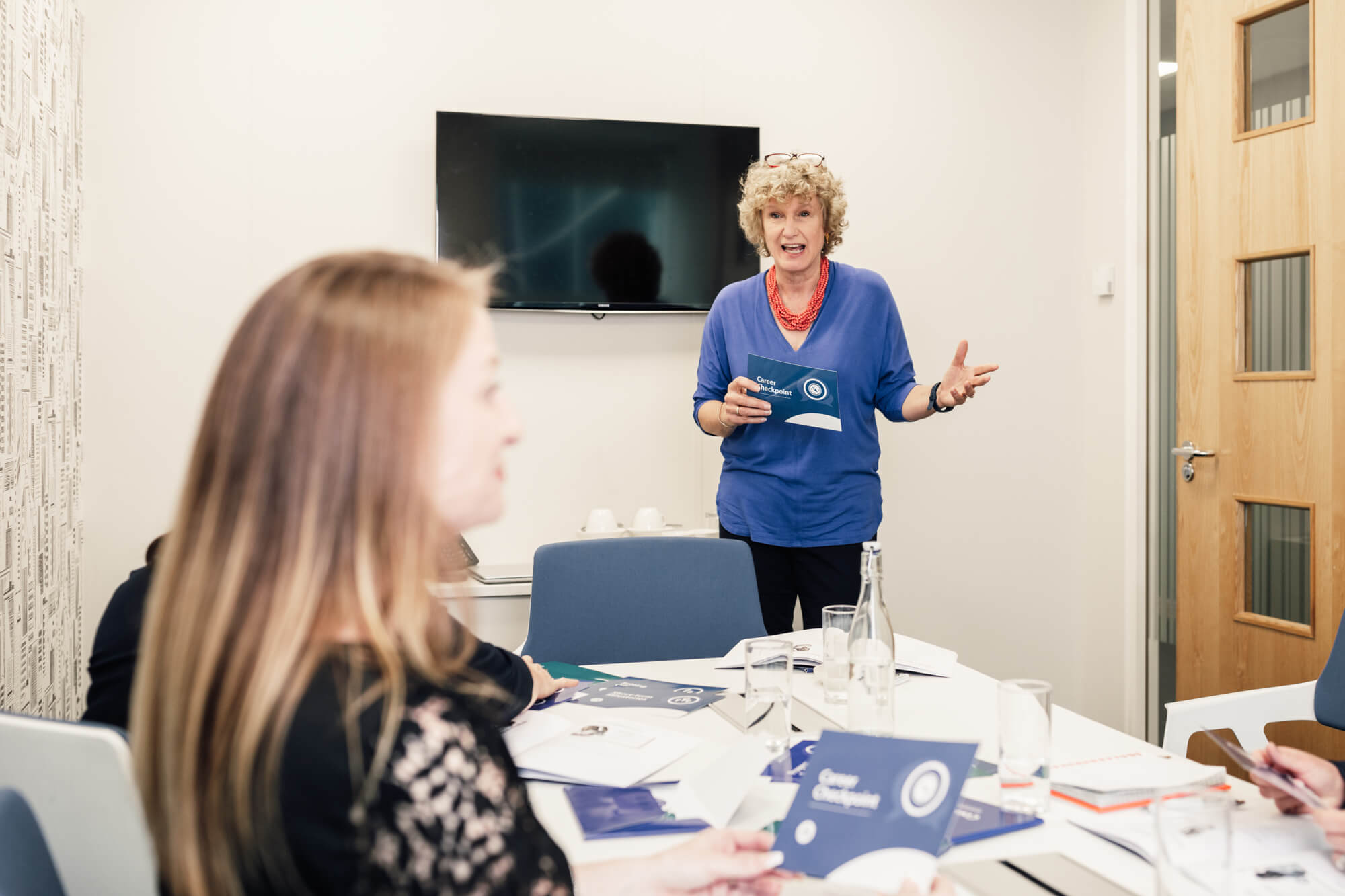 Certified Career Conversations Facilitator Programme course tutor stood up directing participants in office environment