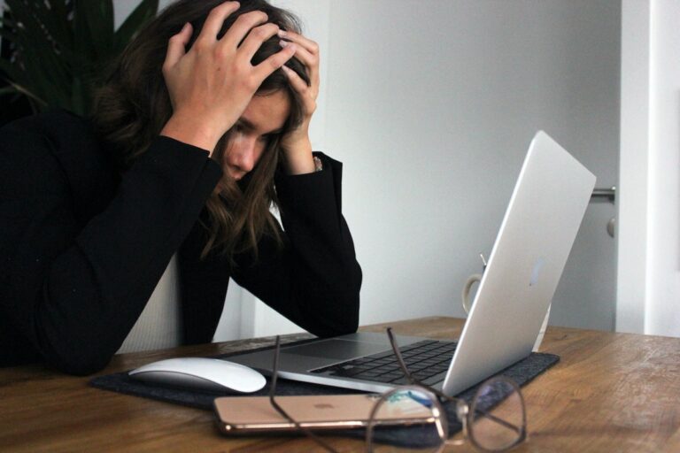 Experiencing Career Burnout person with head in hands at a computer