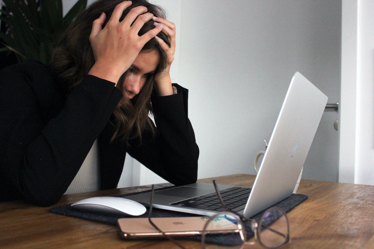 Experiencing Career Burnout person with head in hands at a computer