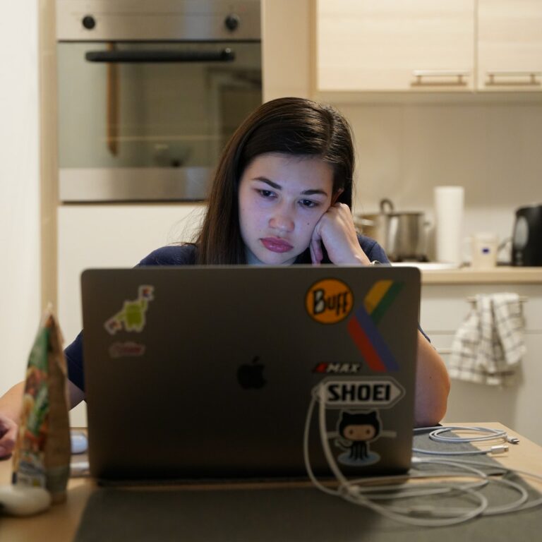 Career Burnout 11 signs to look our for - burntout person sat at a computer in their kitchen looking unhappy