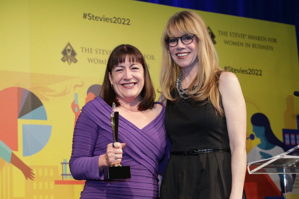 Antoinette on stage with the presenter collecting her award.