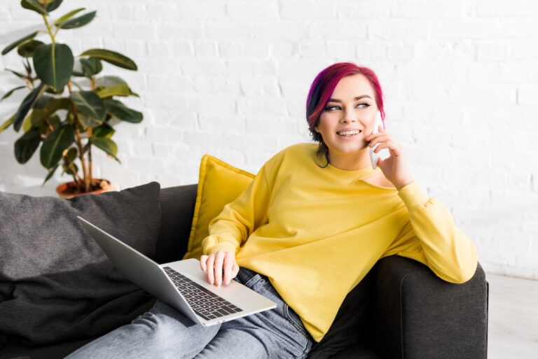 Gen Z enagagement tips for effective career conversations. Woman with pink hair sat on a sofa working.