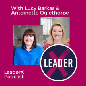 Two women smiling, one in a blue jacket and one in a patterned top, are pictured on a magenta background with the text 