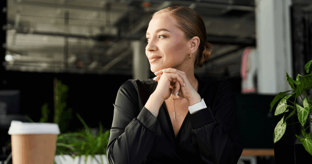 Woman reflecting at her desk, symbolising career clarity and thoughtful career planning in the workplace.