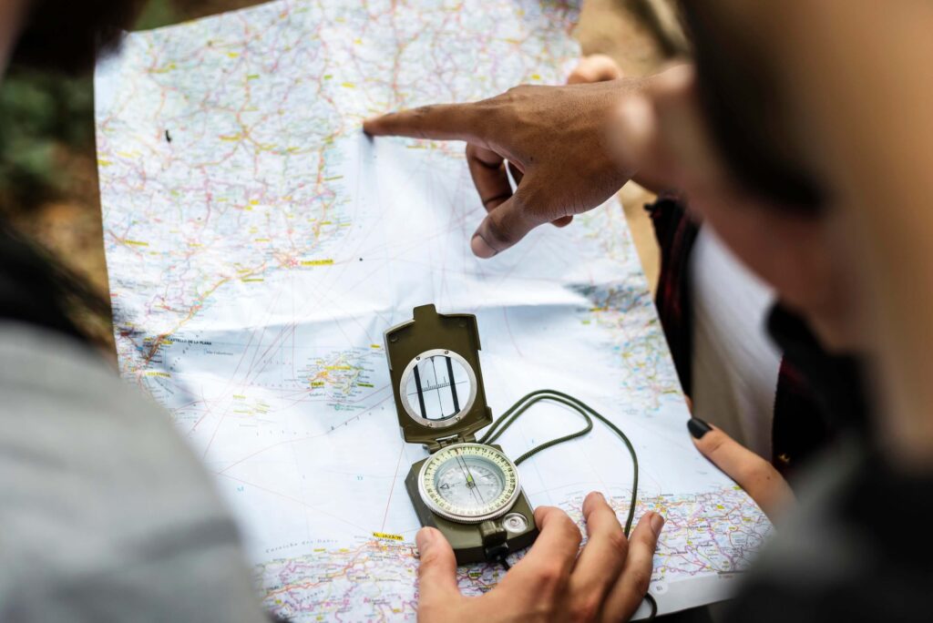 Hands holding a map and compass, navigating without a fixed route