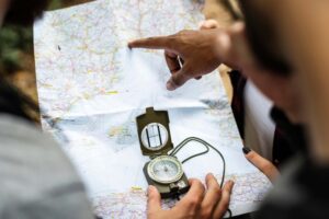 Hands holding a map and compass, navigating without a fixed route